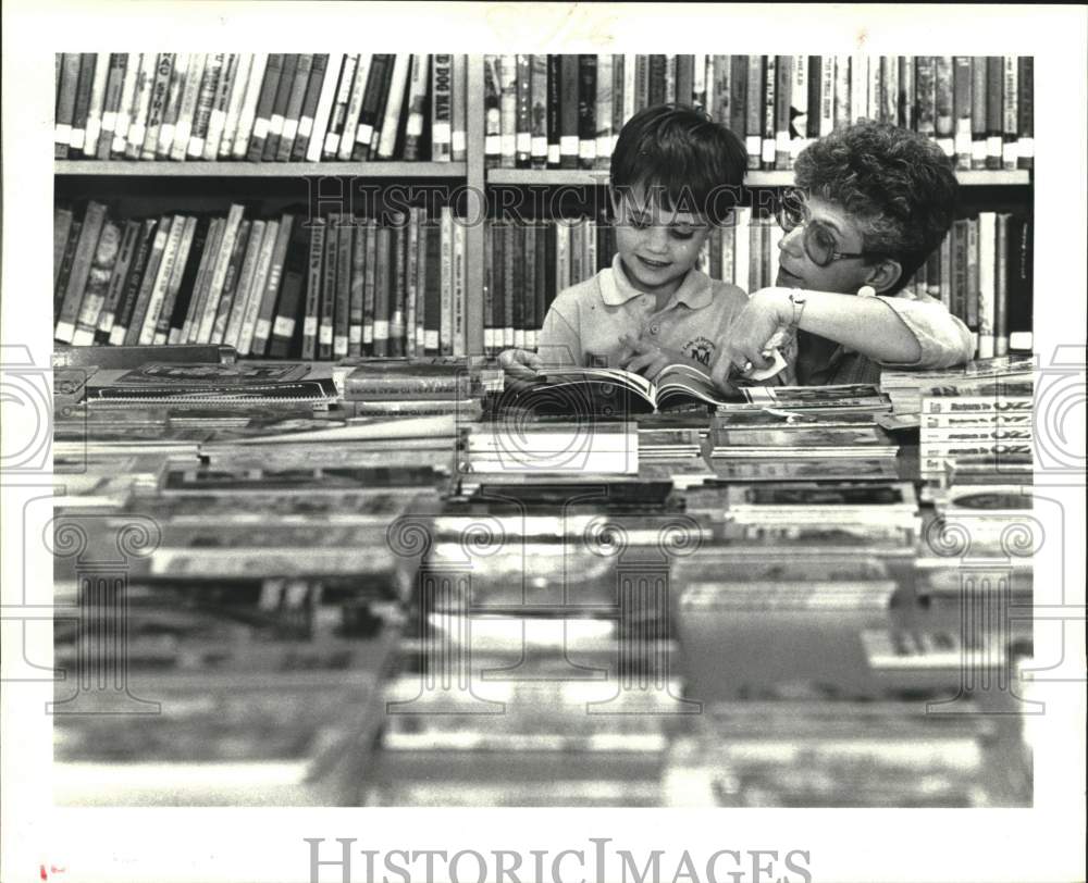 1986 Press Photo Chad Prey gets helped in choosing a book by Barbara Hupe- Historic Images