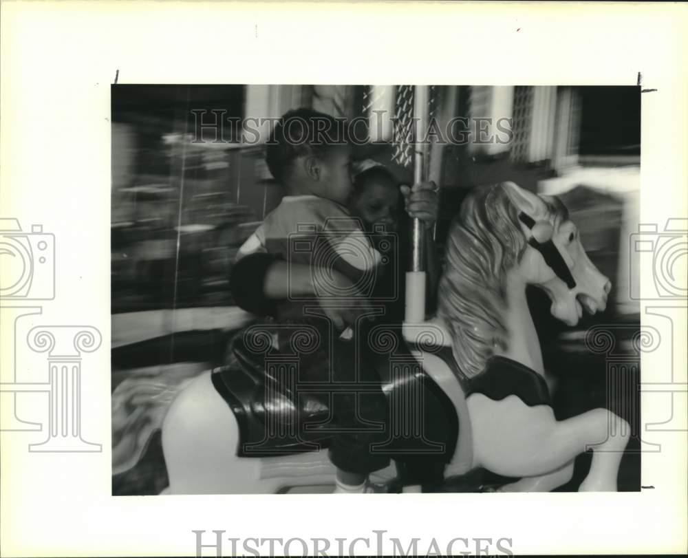 1989 Press Photo Violet Oyster Festival goers ride a merry-go-round- Historic Images