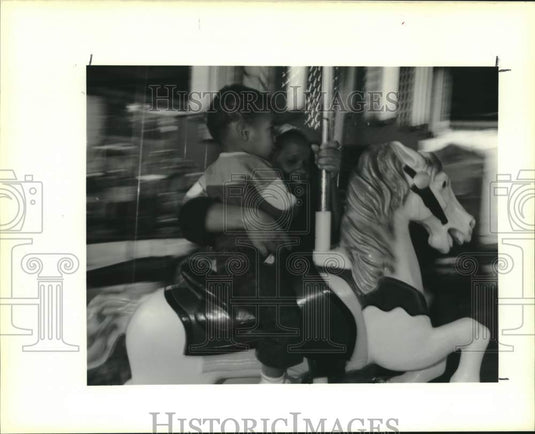 1989 Press Photo Violet Oyster Festival goers ride a merry-go-round- Historic Images