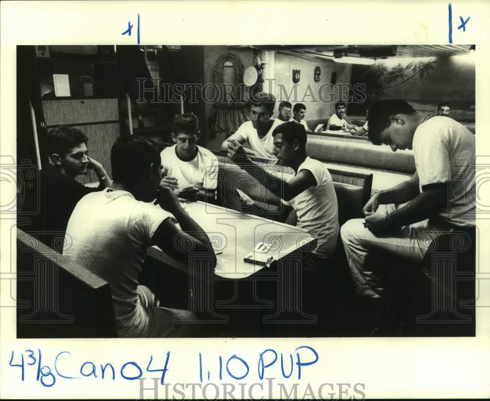 1983 Press Photo Sailors play cards and write letters in their lounge below deck