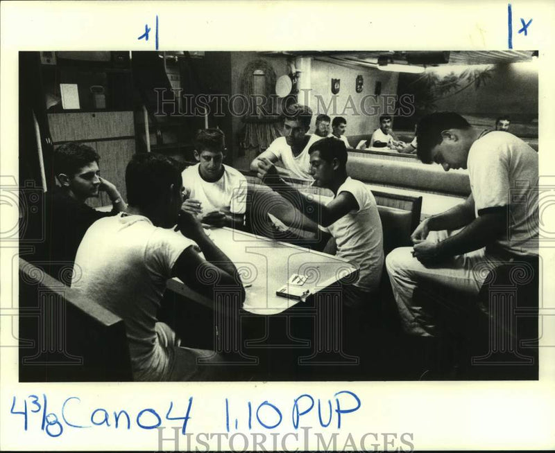 Load image into Gallery viewer, 1983 Press Photo Sailors play cards and write letters in their lounge below deck
