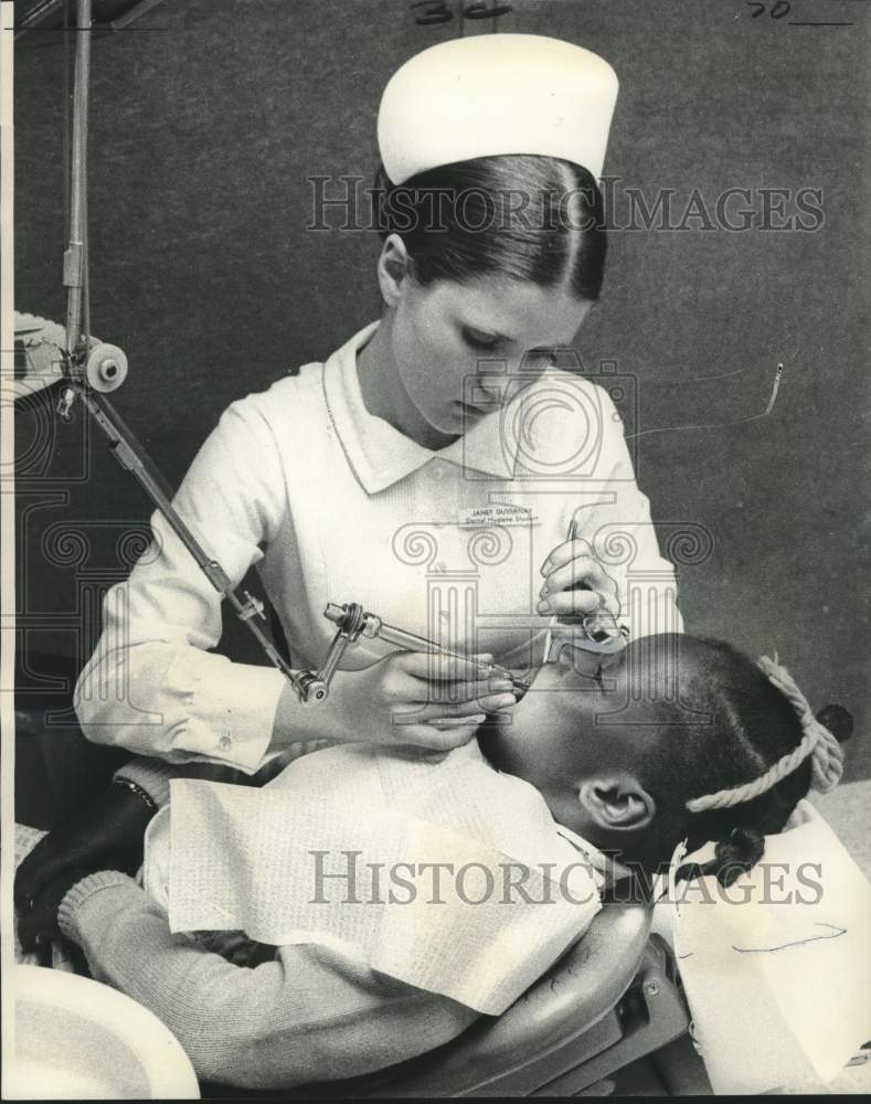 1974 Press Photo Janet Duvernay examines the teeth student Denise Williams- Historic Images