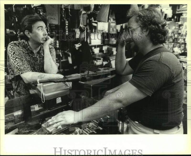 Load image into Gallery viewer, 1994 Press Photo Calvin Oyler buying an MAK 90 at Jewelry and Sporting Goods

