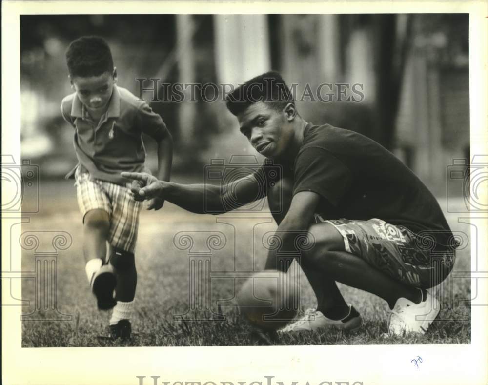 1988 Press Photo Algiers resident Gregory Jenkins teaching his son football- Historic Images