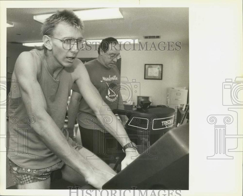 Load image into Gallery viewer, 1991 Press Photo Patrick McKinney on exercise bike, Jimmy Rogers on treadmilll
