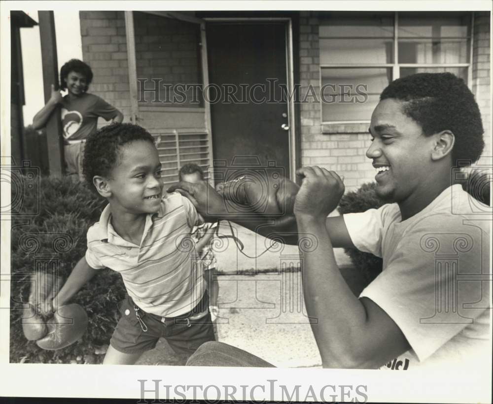 1987 Press Photo Eric Jr. throws a punch at his father Eric Mckee- Historic Images