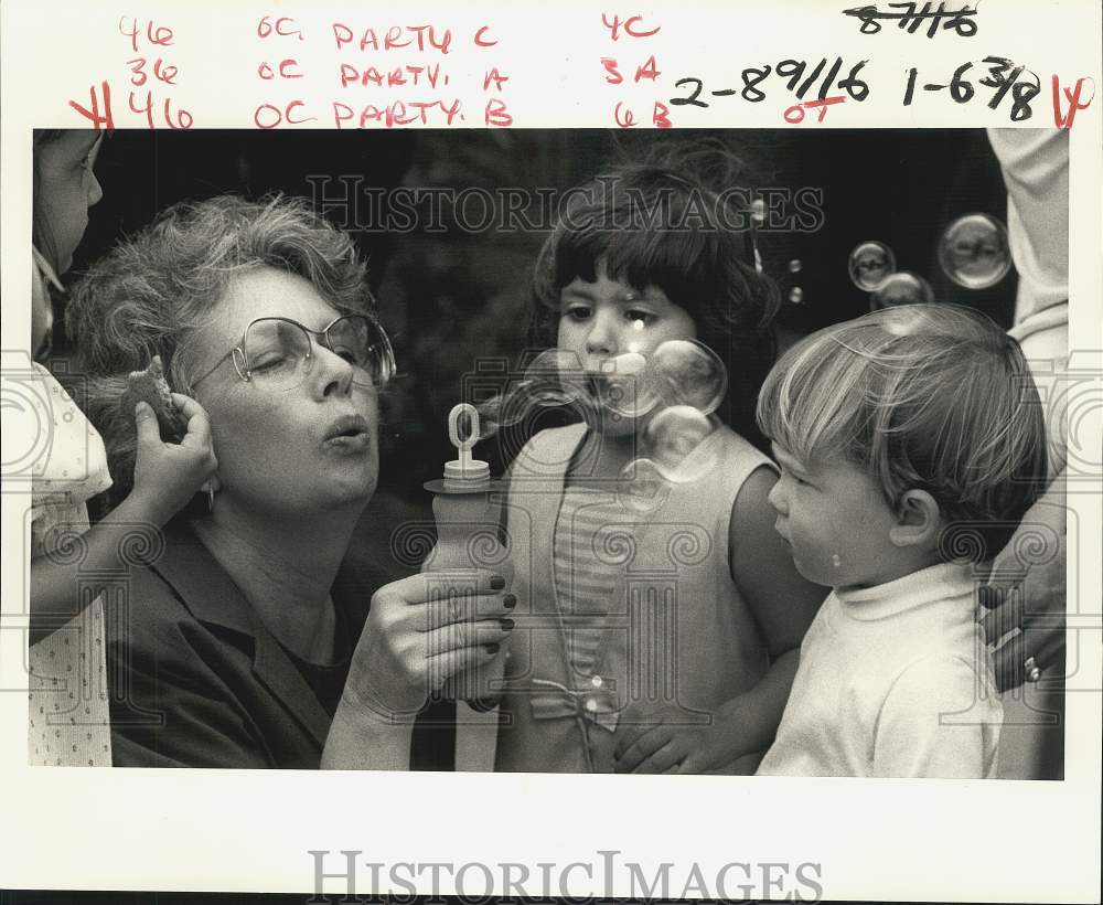 1986 Press Photo Nancy Leinbach blows bubbles for children at birthday party- Historic Images