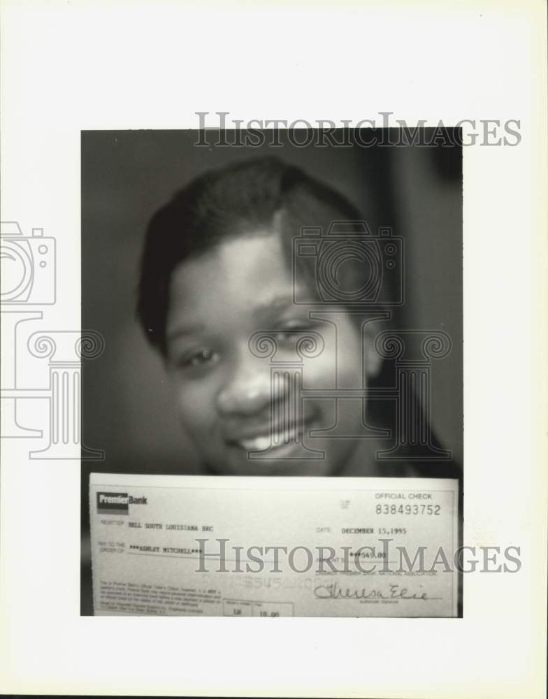 1995 Press Photo Ashley Mitchell holds a check, as her Christmas present- Historic Images