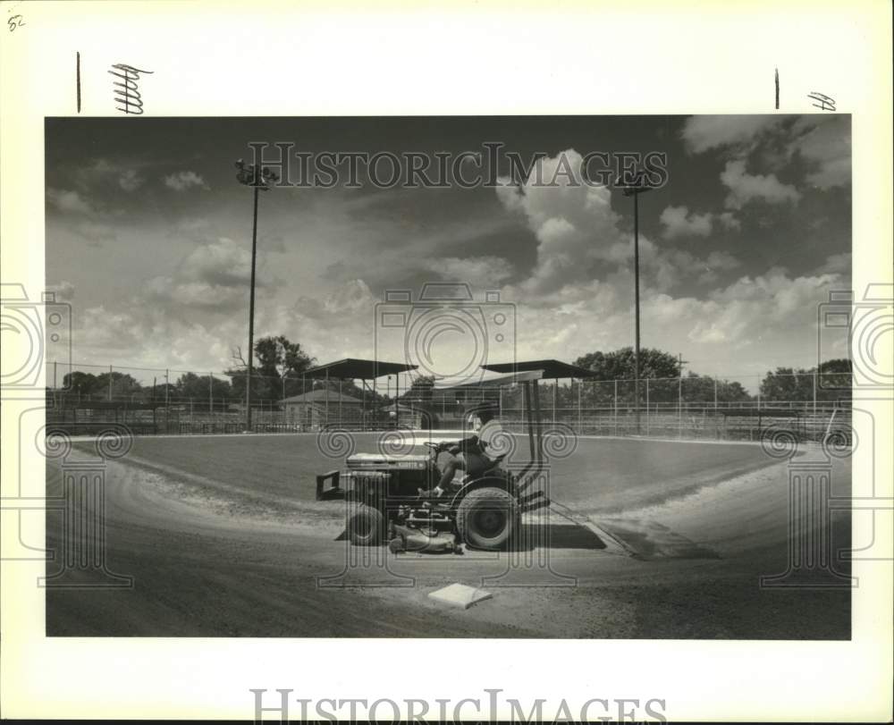 1991 Press Photo Ground keepers rake the infield at Mike Miley Playground