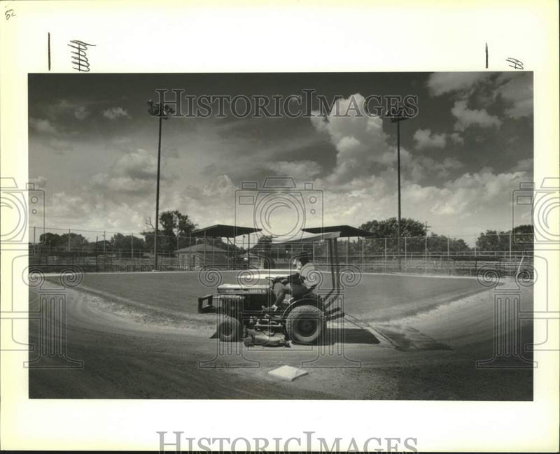 Load image into Gallery viewer, 1991 Press Photo Ground keepers rake the infield at Mike Miley Playground
