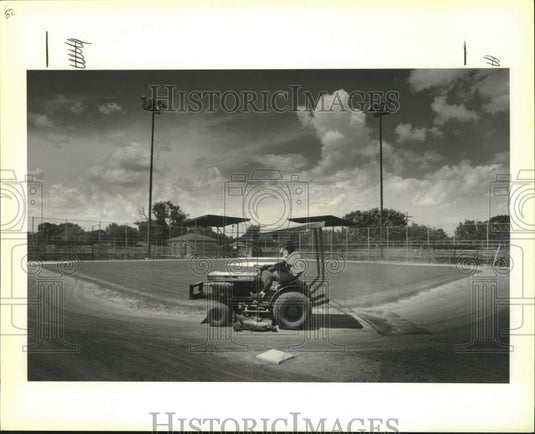 1991 Press Photo Ground keepers rake the infield at Mike Miley Playground