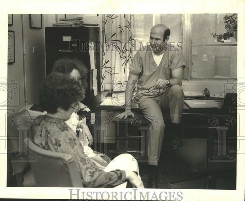 Load image into Gallery viewer, 1981 Press Photo Doctor Richard Morse of Mercy Center talks with his patients
