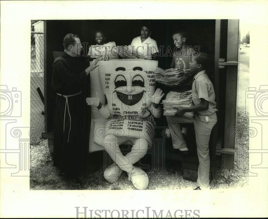 1987 Press Photo Father Basil & St. Mary students gather around Mr. Newspaper