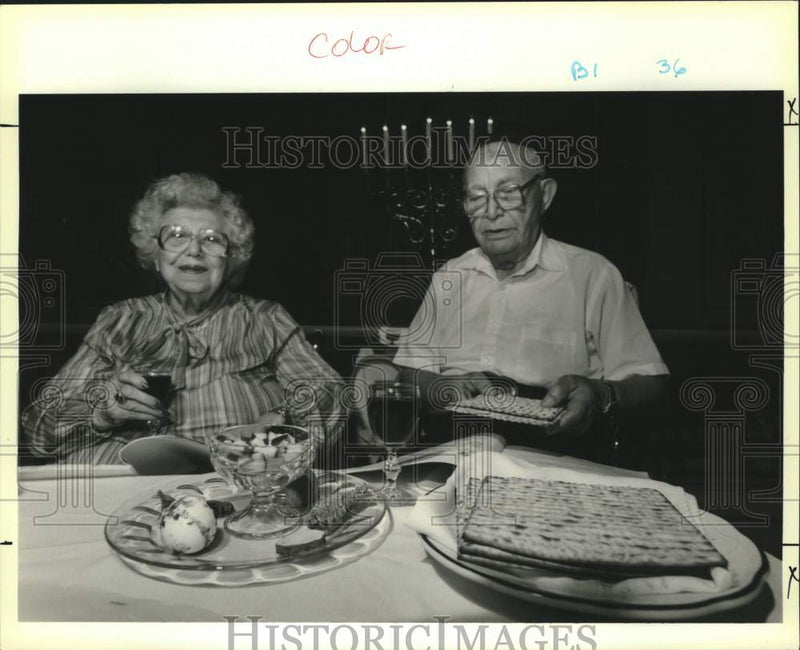 Load image into Gallery viewer, 1990 Press Photo Ida Mintz and Abe Goldberg with traditional Passover meal
