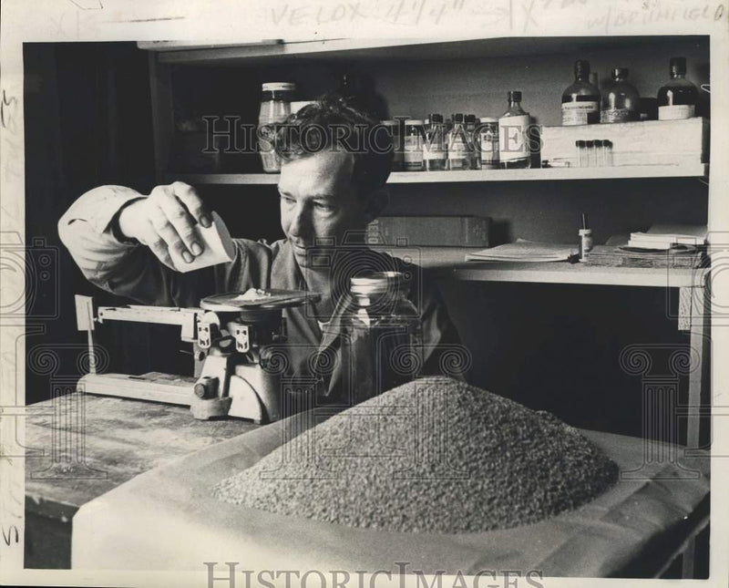 Load image into Gallery viewer, 1963 Press Photo Clarence Stringer measures amount of mirex to treat an acre
