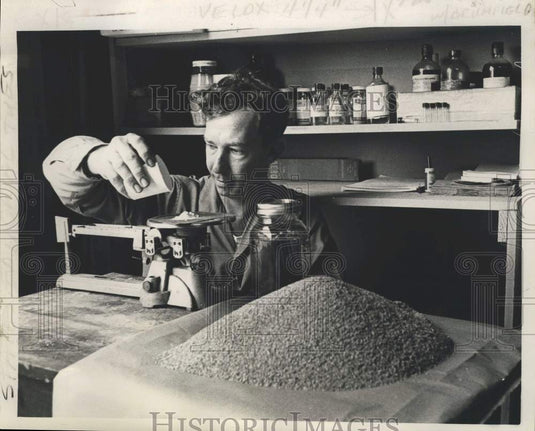 1963 Press Photo Clarence Stringer measures amount of mirex to treat an acre