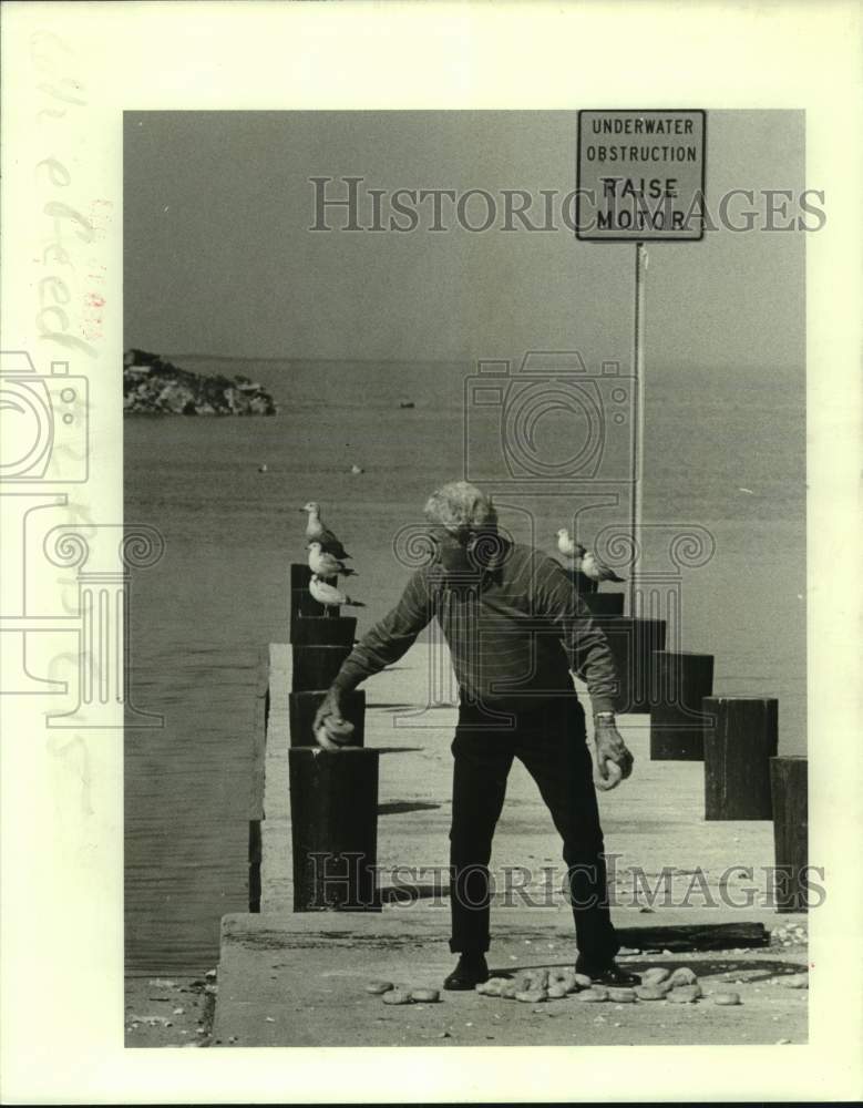 1983 Press Photo Roy Milano feeds a sea gull with doughnut in Metairie- Historic Images