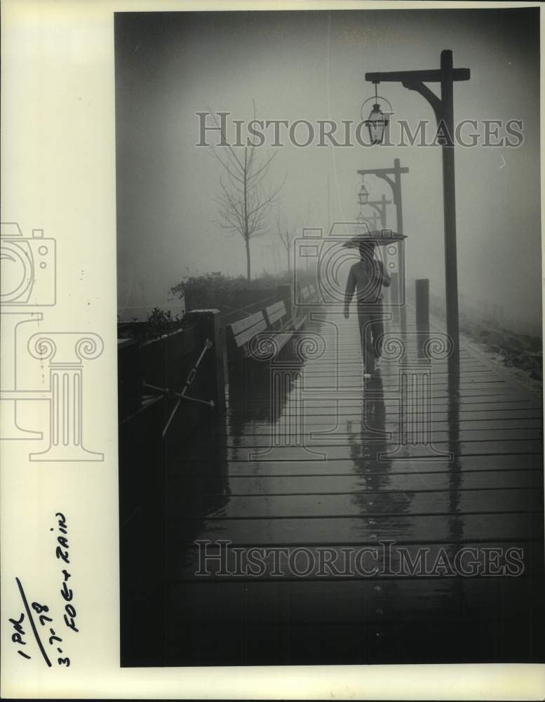 1978 Press Photo A man walks on New Orleans&#39; Moonwalk on a rainy day- Historic Images