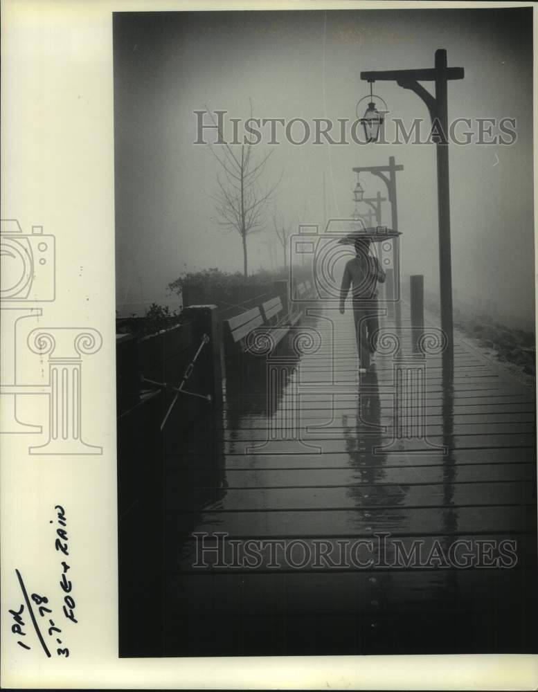 1978 Press Photo A man walks on New Orleans' Moonwalk on a rainy day- Historic Images