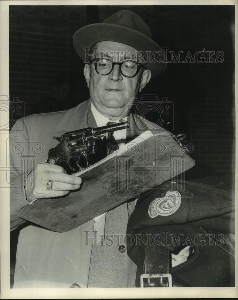 Load image into Gallery viewer, 1964 Press Photo Orleans Parish Investigator Sam Moran looks at caliber revolver
