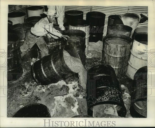 1954 Press Photo Sam Viola dumps another barrel of mash to add ankle deep mess