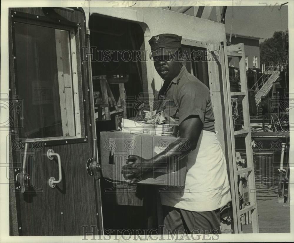 1979 Press Photo Navy Petty Officer Felton Moore carries supplies to kitchen- Historic Images