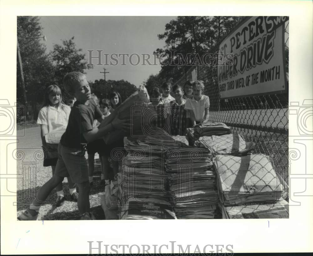 1990 Press Photo Ryan Gauthier loads a bag of newspapers at St. Peter&#39;s School- Historic Images