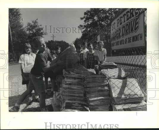 1990 Press Photo Ryan Gauthier loads a bag of newspapers at St. Peter's School- Historic Images