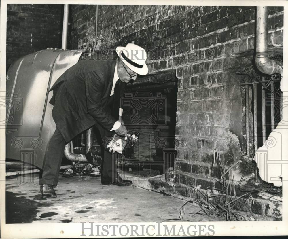 1969 Press Photo Sam Moran, investigator for Coroner&#39;s Office, inspects basement