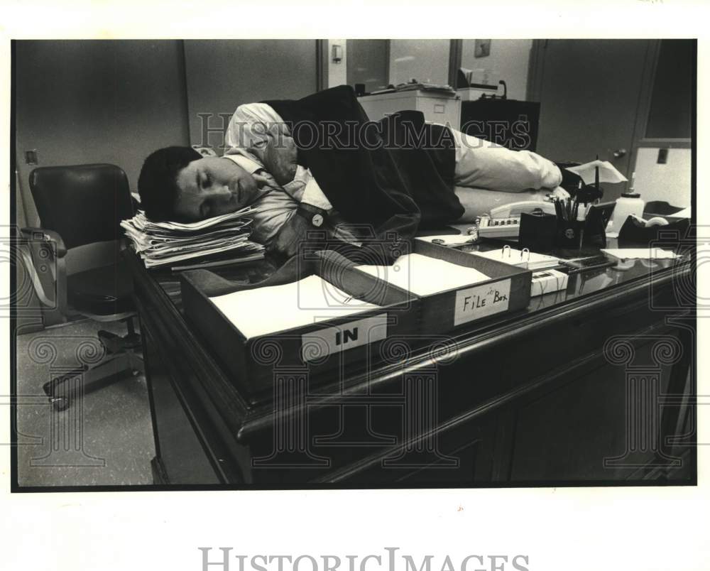 1988 Press Photo Employee naps on desk at the office- Historic Images