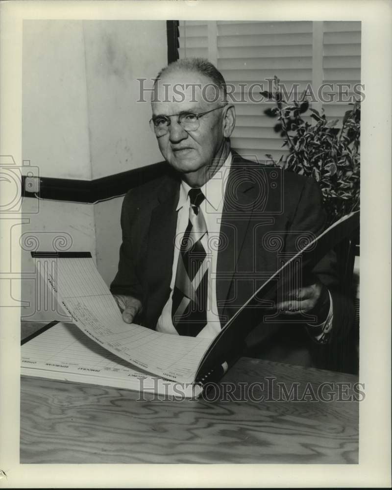 1957 Press Photo Adam Melerine holding a ledger - Historic Images