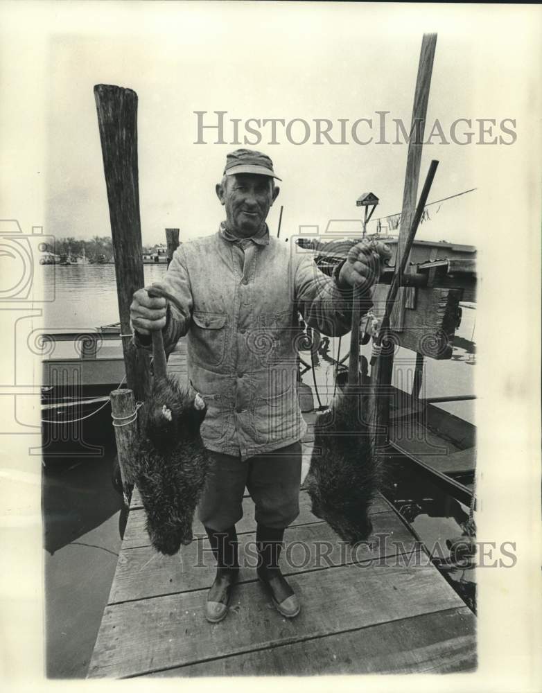 1977 Press Photo Trapper Leo Lombas shows off his day&#39;s catch: two nutrias- Historic Images