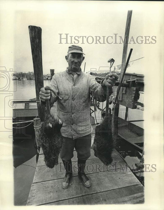 1977 Press Photo Trapper Leo Lombas shows off his day's catch: two nutrias- Historic Images