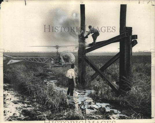 1950 Press Photo Ramon fills water for Herman Painter who stands on burning pole- Historic Images