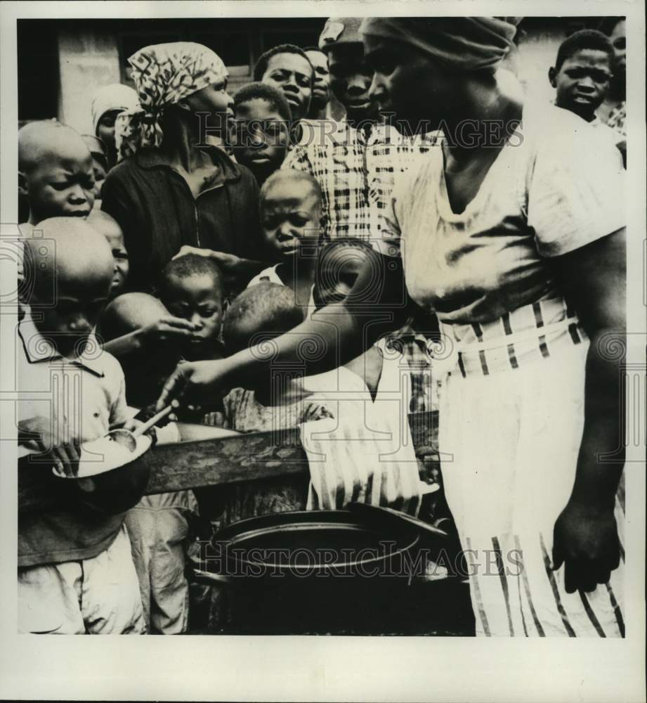 1968 Press Photo A woman gives high-protein food to Nigerian children