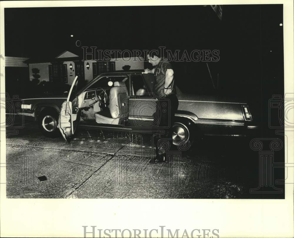 1983 Press Photo Man stands with car after driving through flooded New Orleans- Historic Images