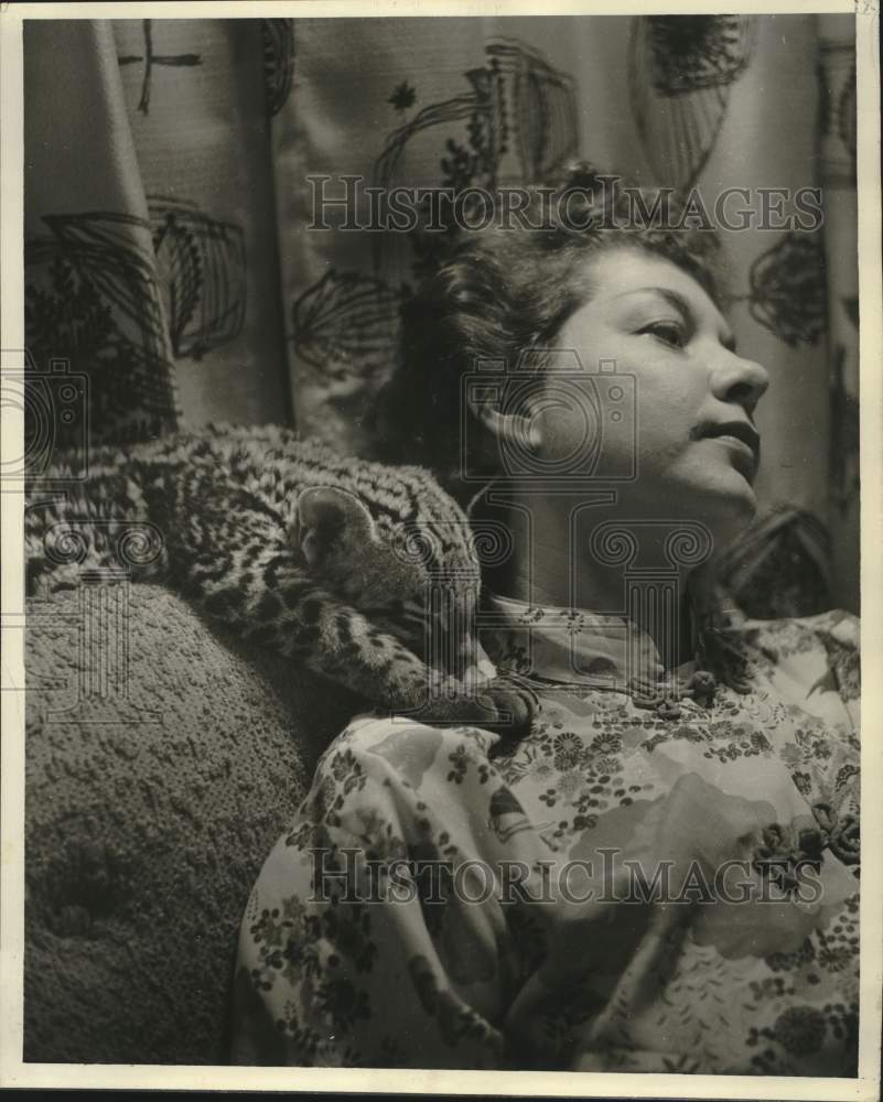 1960 Press Photo Woman rests beside her sleeping ocelot- Historic Images