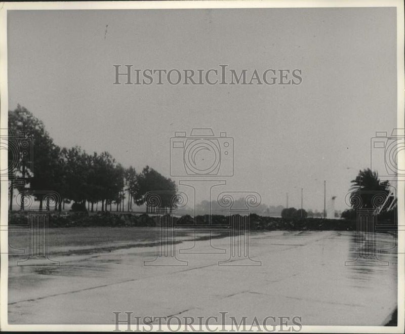 Load image into Gallery viewer, 1965 Press Photo Rain And Wind-Swept Roadway Near Levee - nob98480
