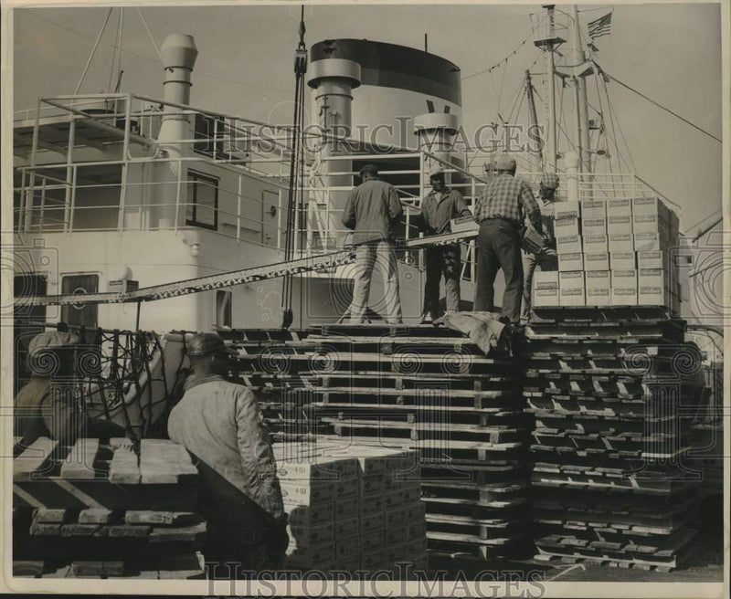 Load image into Gallery viewer, 1963 Press Photo Men Load Cases On Board Ship - nob99073
