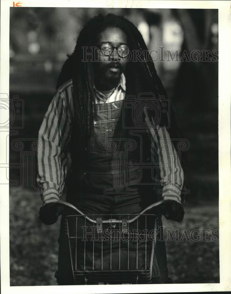 1986 Press Photo Man with long dreadlocks rides bike in Louisiana - noc00633- Historic Images