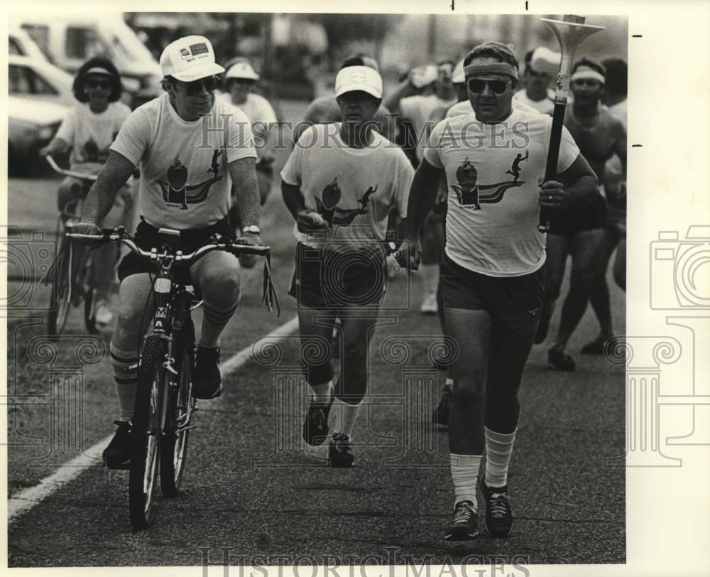 1993 Press Photo Burt Ory with torch running with Admin officers of St. John- Historic Images