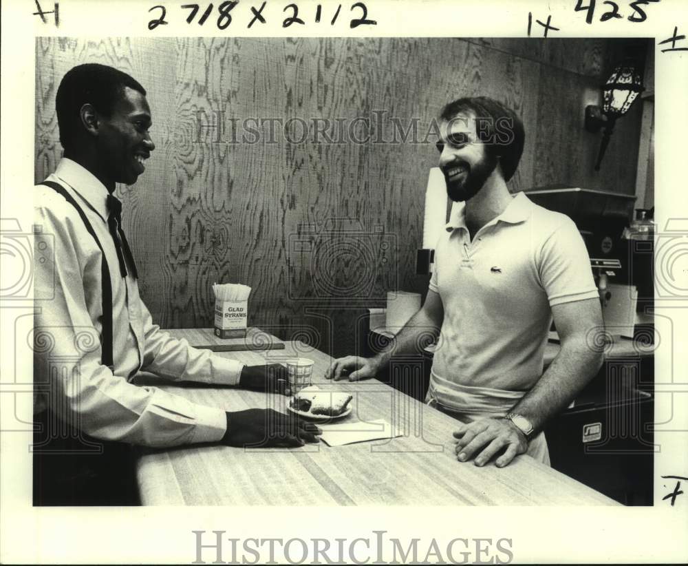 1980 Press Photo Customer Gregory Sartain Gets a Bite at French Market Donuts- Historic Images