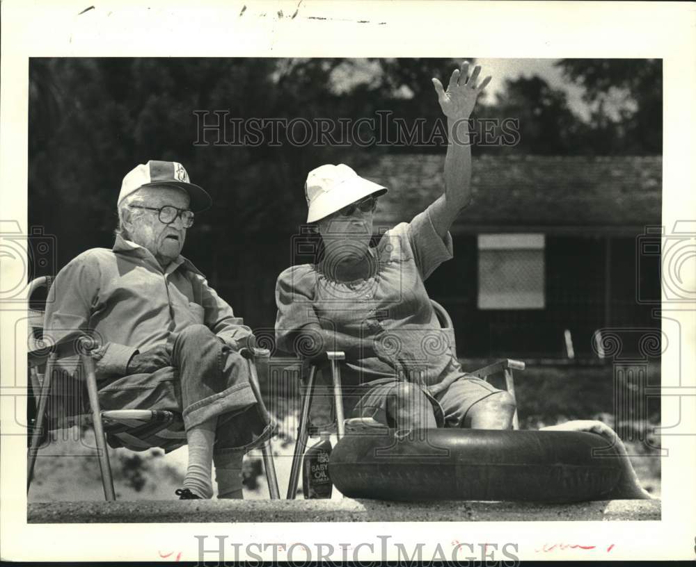1985 Press Photo Lester & Gladys Penouilh wave from Pass Christian Beach seawall