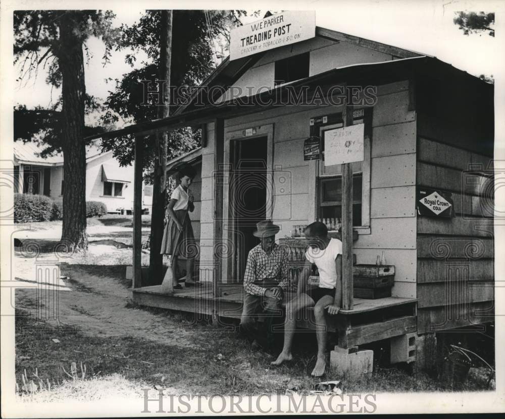 1962 Press Photo Men talk and girl sweeps at New Orleans W.E Parker Trading Post