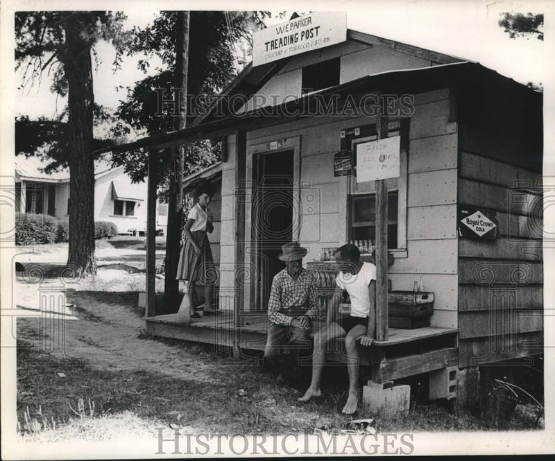 Load image into Gallery viewer, 1962 Press Photo Men talk and girl sweeps at New Orleans W.E Parker Trading Post

