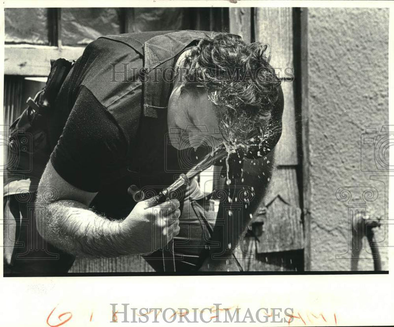 Load image into Gallery viewer, 1984 Press Photo SWAT team member hoses tear gas fumes from his eyes - noc05535
