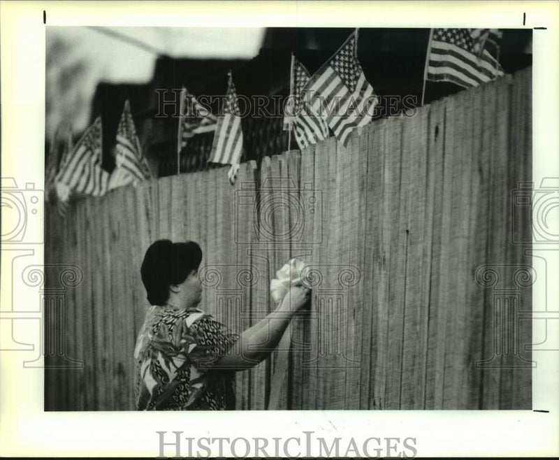 Load image into Gallery viewer, 1991 Press Photo Lady decorates her yard with flags in Metairie Louisiana
