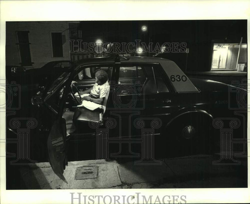 Load image into Gallery viewer, 1982 Press Photo Officer James Pollard doing paper work in his patrol car

