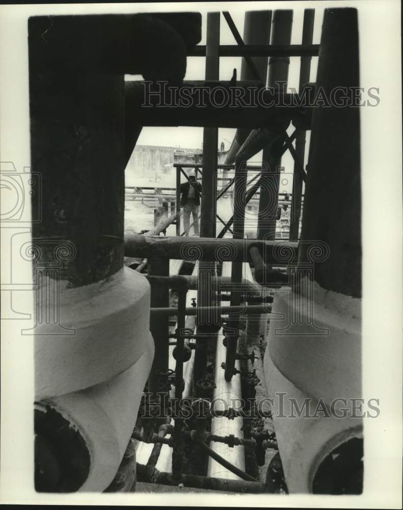 1976 Press Photo Man walks along pipes at Port Sulphur, Louisiana - noc09115
