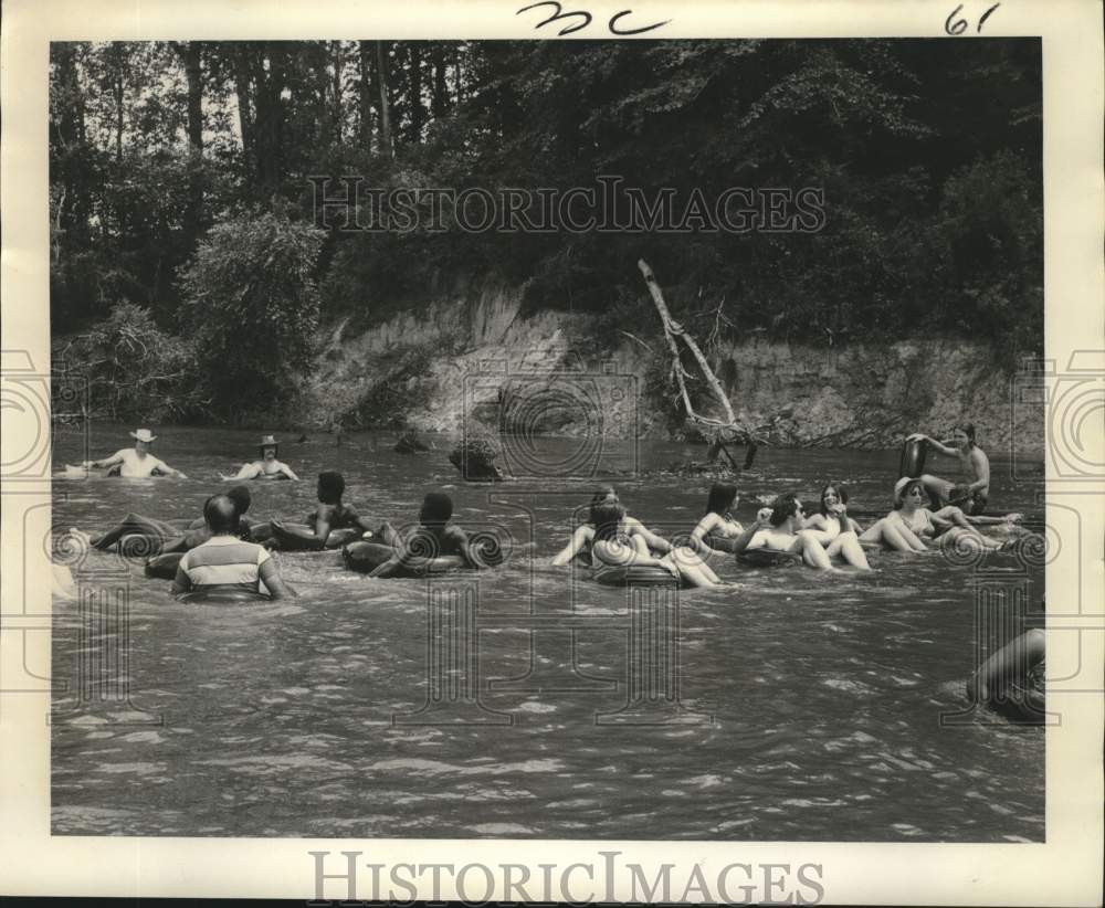 1973 Press Photo A group of friends swimming aboard their lifebuoy - noc09882- Historic Images